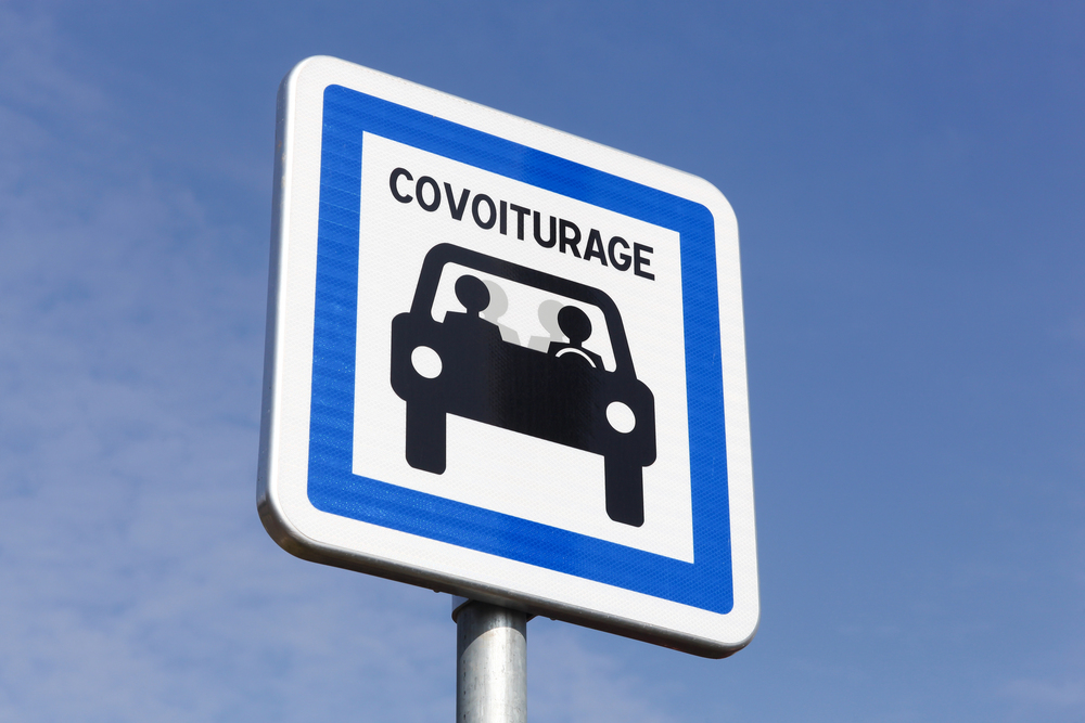 Aire de covoiturage avec voitures et panneau
